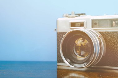 alan eski ve ahşap masa üzerinde tozlu vintage fotoğraf makinesi retro renk efekti ile mavi arka plan kopya