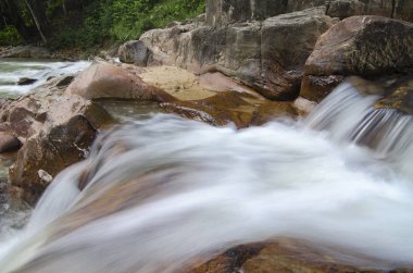 Güzel yeşil ormanın içinden akan tropik şelale akışı toplayan çarpıcı