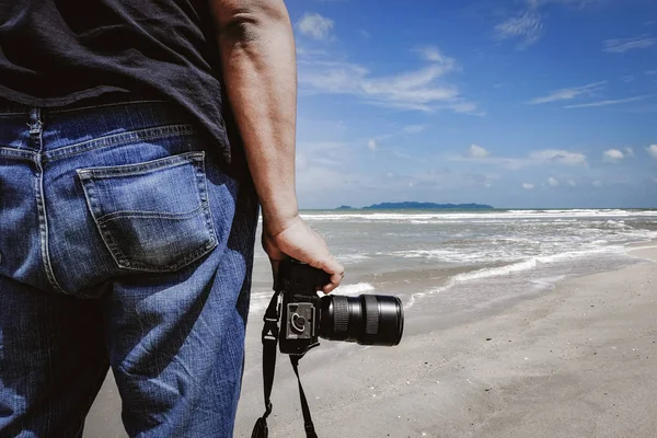 Abgeschnittenes Bild, ein Mann steht mit Kamera am Strand bei sonnigem Tag — Stockfoto