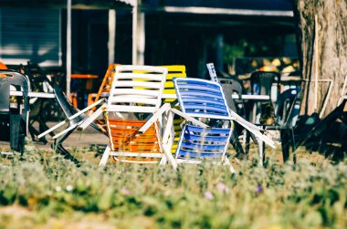 kıyıya yakın parlak güneşli bir günde altında renkli sandalyeler