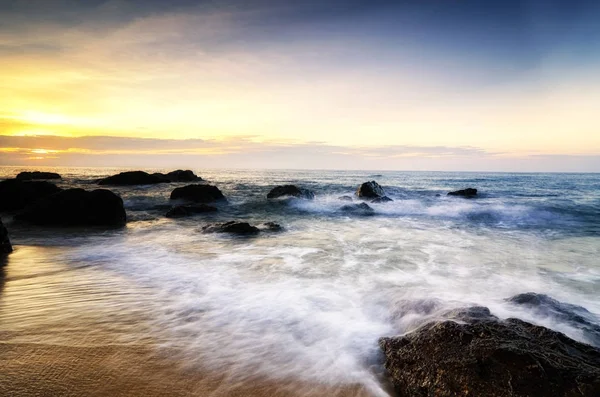 Hermoso paisaje vista al mar sobre impresionante amanecer background.sunlight haz y suave ola golpeando rocas de la playa — Foto de Stock