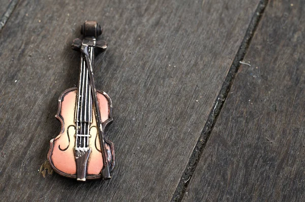 Violin miniature on wooden floor with retro color tone.copy space on the right for text — Stock Photo, Image