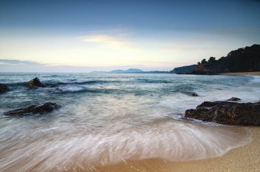 güzel tropikal plaj gündoğumu deniz manzarası. Dalga yumuşak isabet kumlu plaj
