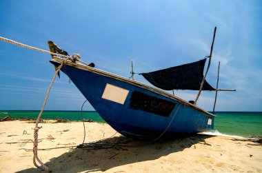 parlak güneşli bir günde altında güzel deniz görünümü ve sandy beach üzerinde geleneksel balıkçı tekne palamarla