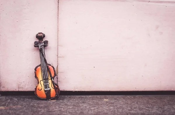 Music passion and hobby concept, violin miniature over wooden wall with retro color tone — Stock Photo, Image