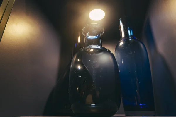 low light shot image of bottles display on rack.