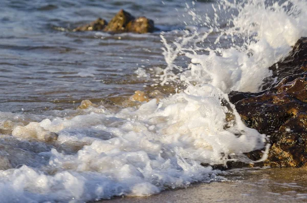 Splashing wave while hitting the rock at the beach — Stock Photo, Image