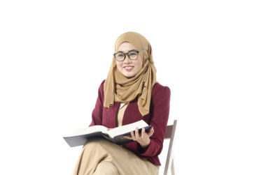 oturma ve beyaz arka plan üzerinde izole ona kitap okumak genç üniversite öğrencisi.