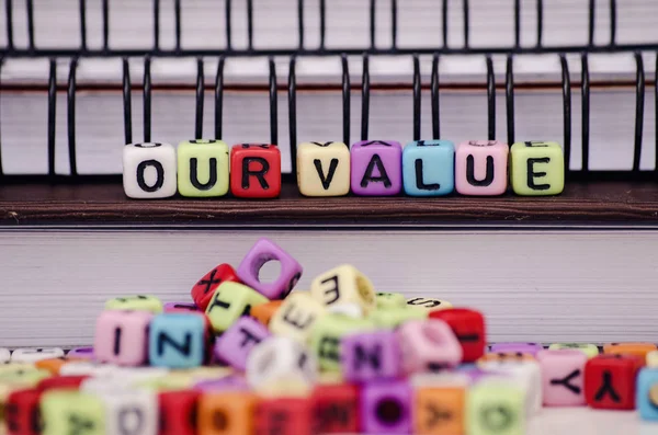 cube dices with word OUR VALUE on note book. Selective focus and shallow depth of field