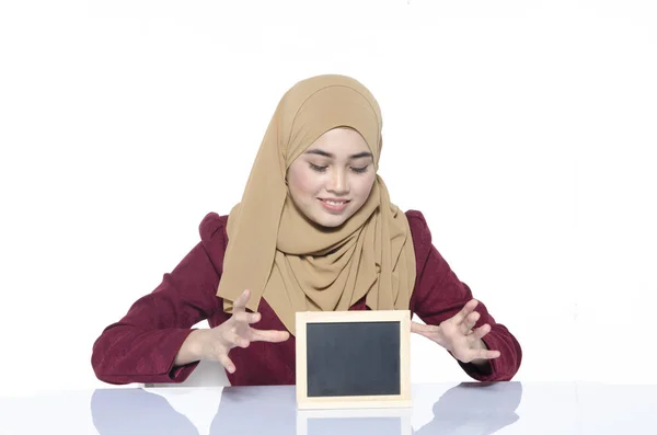 Hermosa dama con hijab sentado con pizarra en blanco para el texto. cara sonriente ideal para el concepto de publicidad —  Fotos de Stock