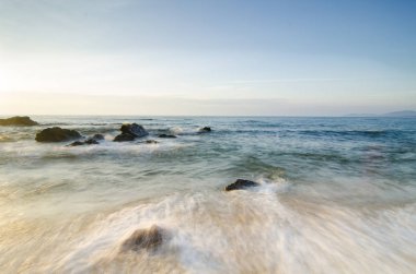 güzel tropikal plaj gündoğumu deniz manzarası. Dalga yumuşak isabet kumlu plaj