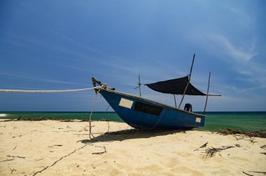 Güzellik doğada, parlak güneşin altında ıssız kum plajındaki mahsur balıkçı teknesi