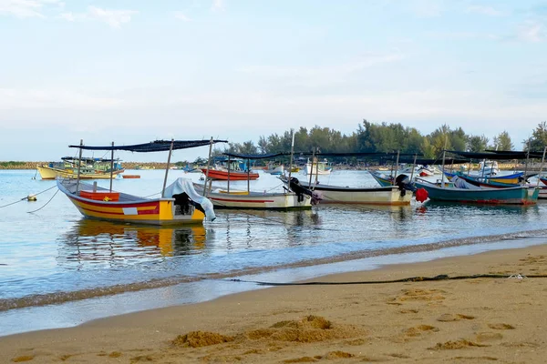 Традиционная рыбацкая лодка пришвартована над красивым видом на море и песчаным пляжем в яркий солнечный день — стоковое фото