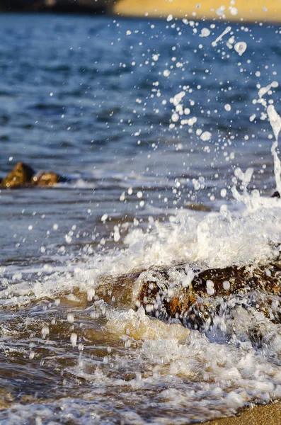 Sahilde rock isabet ederken sıçramasına dalga — Stok fotoğraf