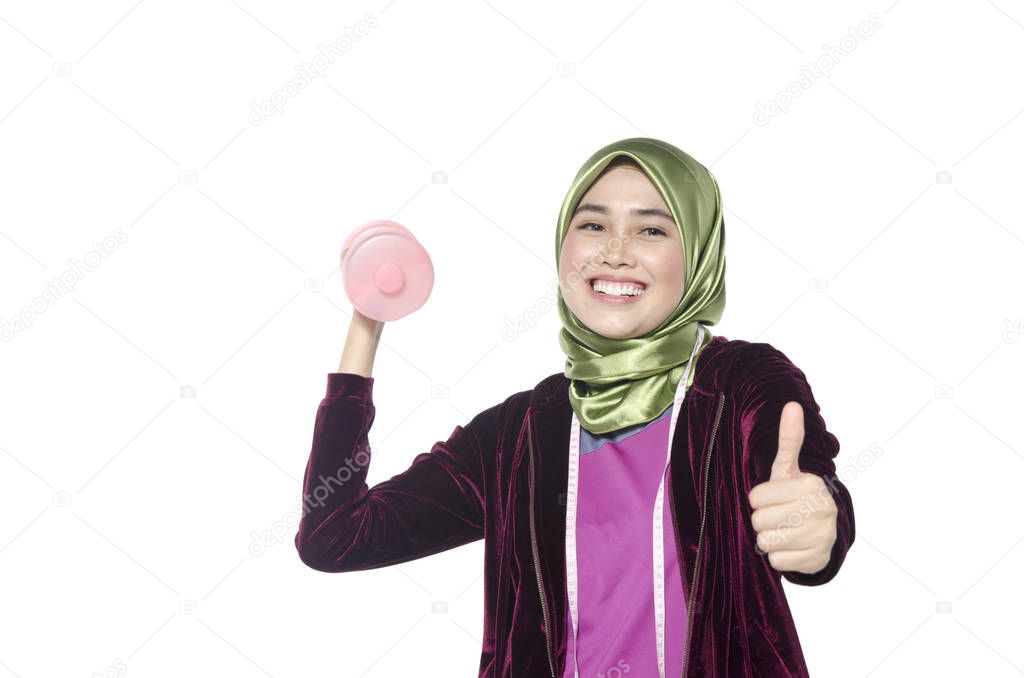 Portrait of a healthy hijab woman with dumbbells promoting a healthy fitness and lifestyle concept