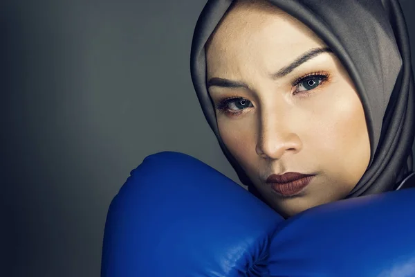 Creatieve ideeën concept, aggrassive jonge muslimah zakenvrouwen met Bokshandschoen over donkere achtergrond — Stockfoto
