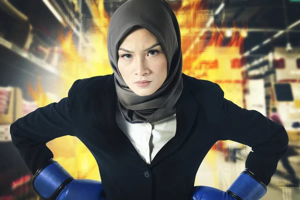Geslaagde en agressieve jonge muslimah zakenvrouwen met Bokshandschoen over abstracte dubbele blootstelling achtergrond — Stockfoto
