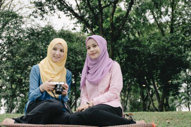 eğleniyor, muslimah harcamak zaman birlikte fotoğraf görüntüleme Park'ta