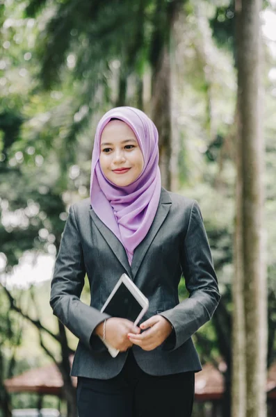 微笑年轻的职业 muslimah 女实业家在公园里拿着一块碑 — 图库照片