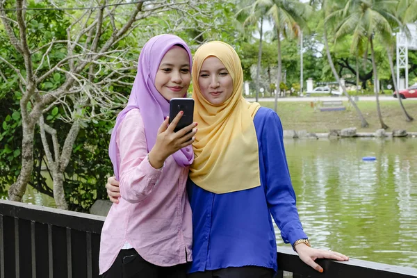 Vriendschap en geluk concept. Portret van glimlach jonge vrouwen selfie op houten brug — Stockfoto