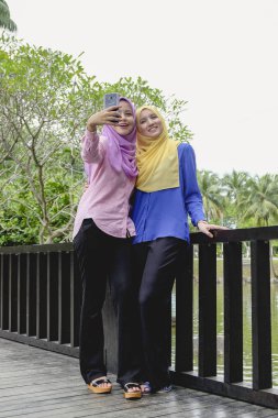 Eğlence, mutlu güzel muslimah harcamak zaman birlikte ve selfie Şehir Parkı