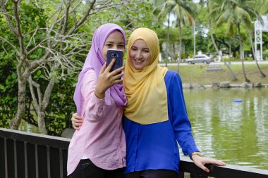 Eğlence, mutlu güzel muslimah harcamak zaman birlikte ve selfie Şehir Parkı