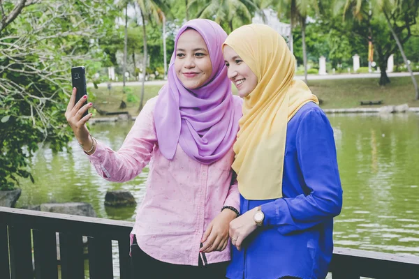 Glada vackra muslimah att ha kul, tillbringa tid tillsammans och selfie i stadsparken — Stockfoto