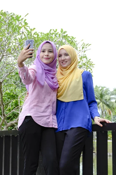 Felice bella muslimah divertirsi, trascorrere del tempo insieme e selfie al parco della città — Foto Stock