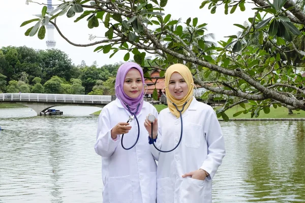 Dokter berpose dengan stetoskop mereka di taman — Stok Foto