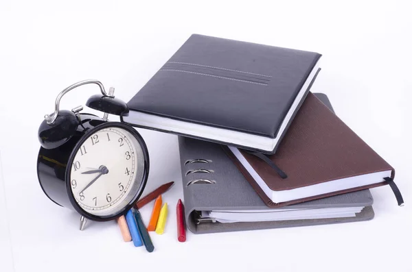 Βιβλίο με ωρολογιακή ρολόι vintage και πολύχρωμες ξυλομπογιές σε λευκό πίνακα. — Φωτογραφία Αρχείου