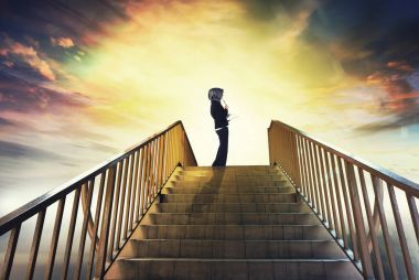 Genç profesyonel holding kitap ve onun geleceği ifade etmek için arka plan bakmak