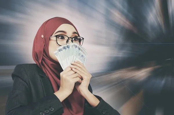 Surprised face expression holding money over abstract background — Stock Photo, Image