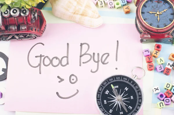 Καλή αντίο λέξη γραμμένη με το χέρι και είδη διακόσμησης σε λευκό γραφείο — Φωτογραφία Αρχείου