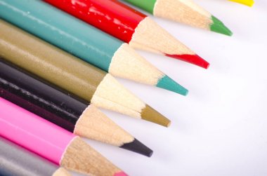 Beyaz arka planda back-to-okul ve eğitim kavramı için ideal renkli renk kalem yığılmış