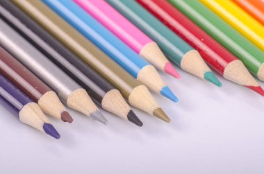 Beyaz arka planda back-to-okul ve eğitim kavramı için ideal renkli renk kalem yığılmış