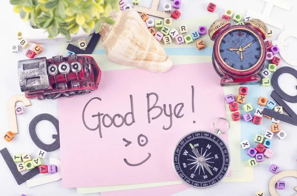 GOOD BYE word written by hand and decoration items on white desk — Stock Photo, Image