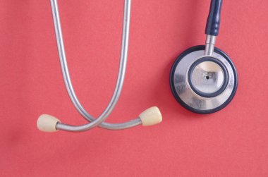 Kullanılan stetoskop tıbbi ve sağlık kavramı için ideal kırmızı arka plan üzerinde asılı