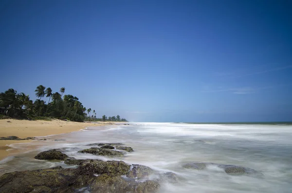 Isla tropical salvaje y costa rocosa del mar bajo día soleado brillante y fondo azul del cielo . — Foto de Stock