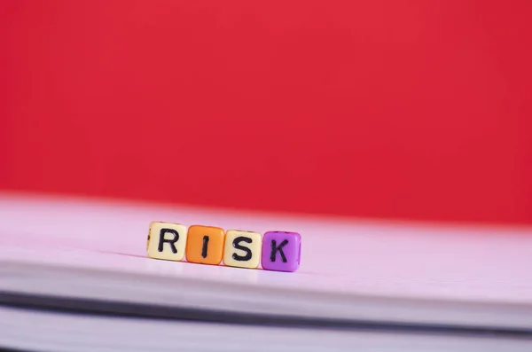 Concepto de gestión de riesgos.Cubo de palabras de riesgo en libro sobre fondo rojo — Foto de Stock