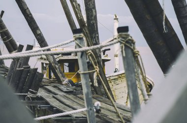 Güzel kırsal manzara, balıkçı teknesi bulutlu arka planda ahşap iskelenin yanında demirlemiş.