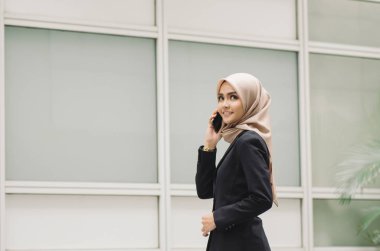Ofisteki genç bir kadının portresi. Cep telefonunda mutlu bir yüz ifadesi olan biriyle konuşuyor..