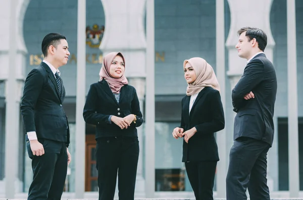 Group of young executive people in formalwear discussing something and gesturing