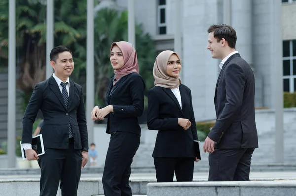 Group of young executive people in formalwear discussing something and gesturing