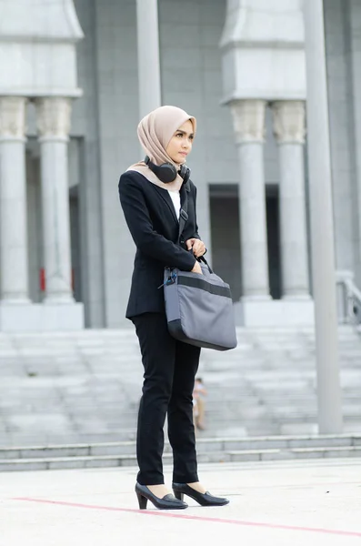 Joven ejecutiva mujer de negocios en traje negro de pie con expresión de confianza en la cara — Foto de Stock