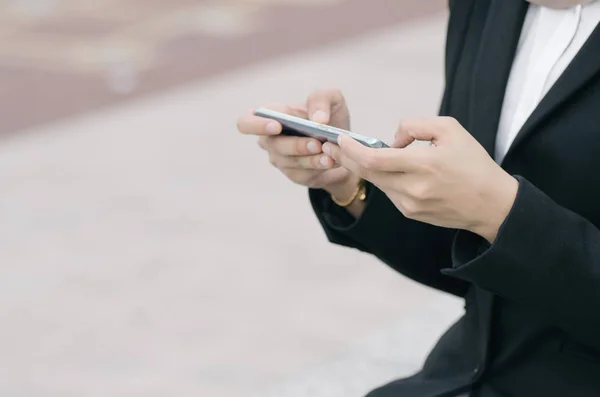 Неопознанная деловая женщина в элегантном костюме сидит с мобильным телефоном — стоковое фото
