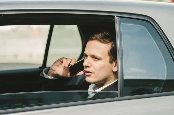 Портрет молодого бизнесмена, разговаривающего с кем-то по мобильному телефону со счастливым выражением лица . — стоковое фото