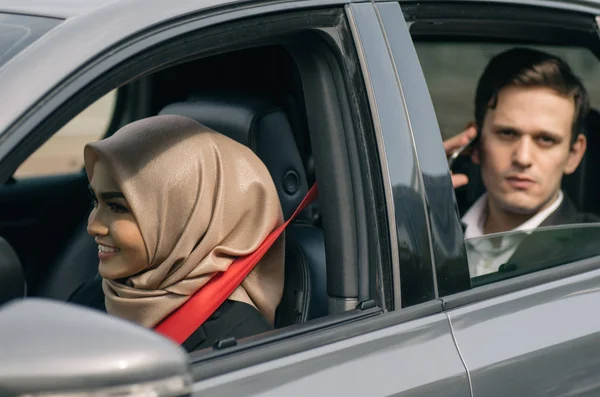 Araba ile seyahat eden otomobil penceresinden manzara, mutlu ve ciddi yüz ifadesi olan genç yönetici araba paylaşım konsepti