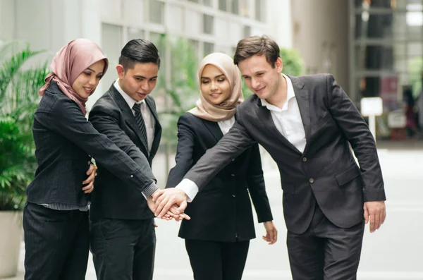 Arbeta tillsammans eller lagarbete koncept.Grupp av unga affärsmän med kostym lägga händerna på händerna. — Stockfoto