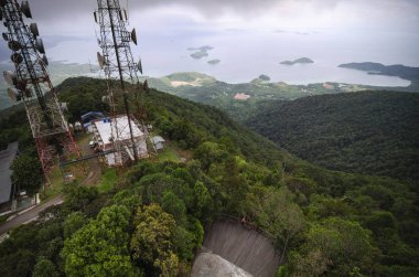 Tepedeki radyo, televizyon ve iletişim anten kulesi bulutlu arka planda.