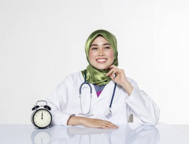 Young doctor with hijab. happy face expression siiting in front laptop ideal for stress management concept